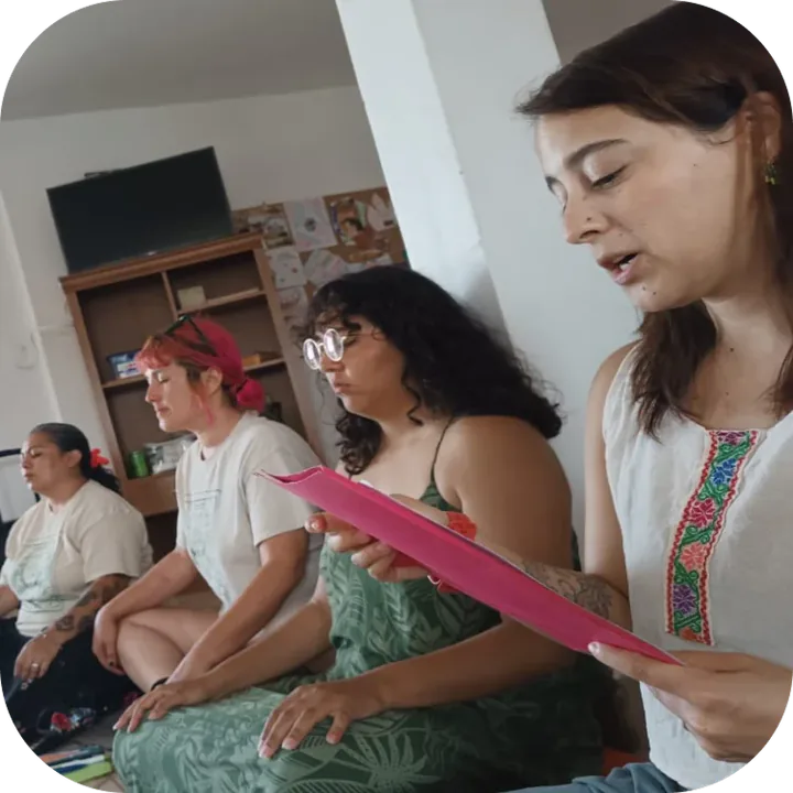 Taller de Espacio Disfrute Colectivo: participantes sentadas en el suelo leen juntas