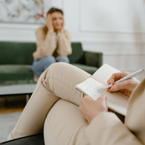 Una mujer conversa con su terapeuta durante una sesión de psicoterapia
