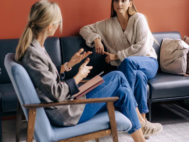 Dos mujeres conversan sentadas frente a frente